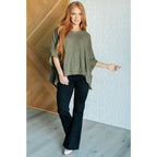 Our Perfectly Poised Hooded Poncho is crafted from a soft olive lightweight and stretchy. ribbed jersey knit.