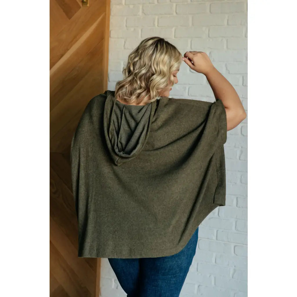 Our Perfectly Poised Hooded Poncho is crafted from a soft olive lightweight and stretchy. ribbed jersey knit.