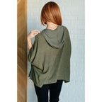 Our Perfectly Poised Hooded Poncho is crafted from a soft olive lightweight and stretchy. ribbed jersey knit.