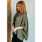 Our Perfectly Poised Hooded Poncho is crafted from a soft olive lightweight and stretchy. ribbed jersey knit.