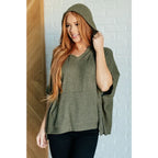 Our Perfectly Poised Hooded Poncho is crafted from a soft olive lightweight and stretchy. ribbed jersey knit.