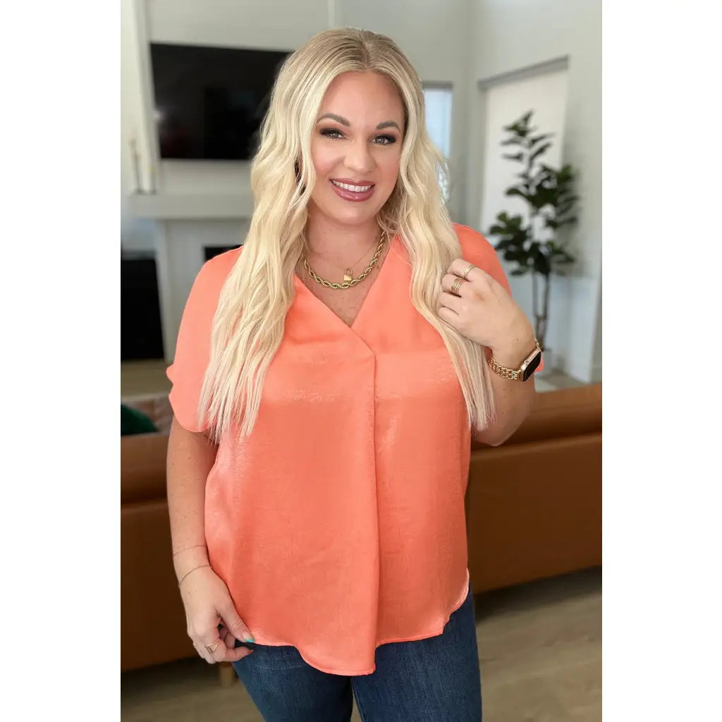Discover effortless chic with our Pleat Front V-Neck Top in Persimmon! Made of luxurious satin this blouse features