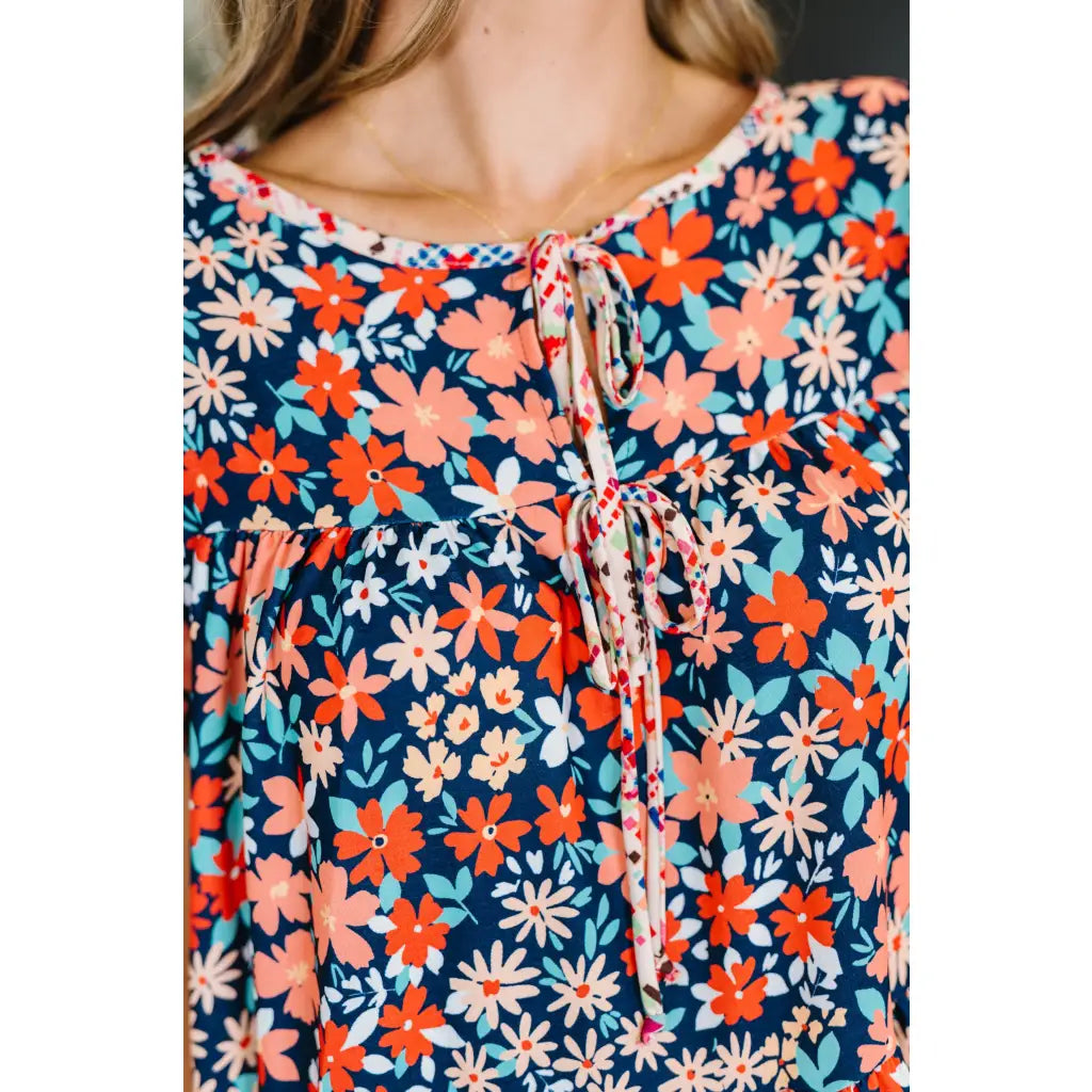 Shop the Pocket of Petals flutter sleeve mini dress in navy and coral. A flattering tiered silhouette with pockets