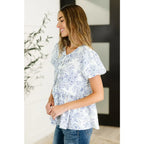 A romantic toile-inspired plus size friendly blouse in ivory and blue with dainty bows a flattering peplum fit. Sweet