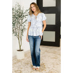 A romantic toile-inspired plus size friendly blouse in ivory and blue with dainty bows a flattering peplum fit. Sweet