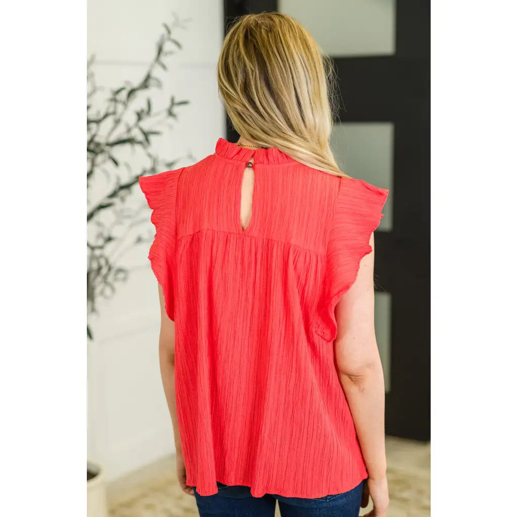 Coral flutter sleeve blouse with ruffle neckline and keyhole back. Mid-stretch knit in regular plus sizes SM-3XL. Soft