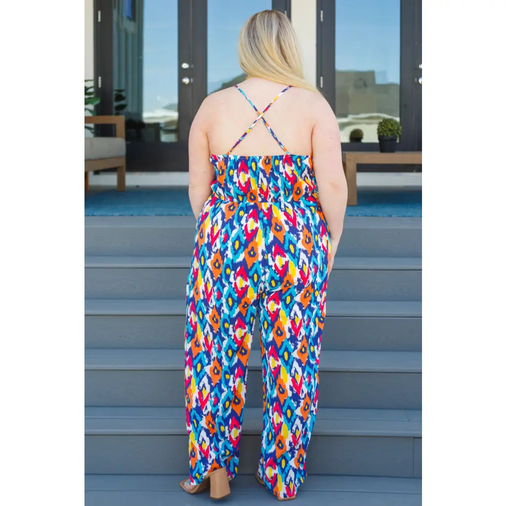 Turn heads in the vibrant Seek Me Out Jumpsuit. Plus size-friendly bold print adjustable straps and flattering fit.