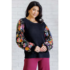 She is the Party Floral Sequins Mesh Sleeve Top brings sparkle! The black ribbed knit and banded round neckline create