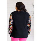 She is the Party Floral Sequins Mesh Sleeve Top brings sparkle! The black ribbed knit and banded round neckline create