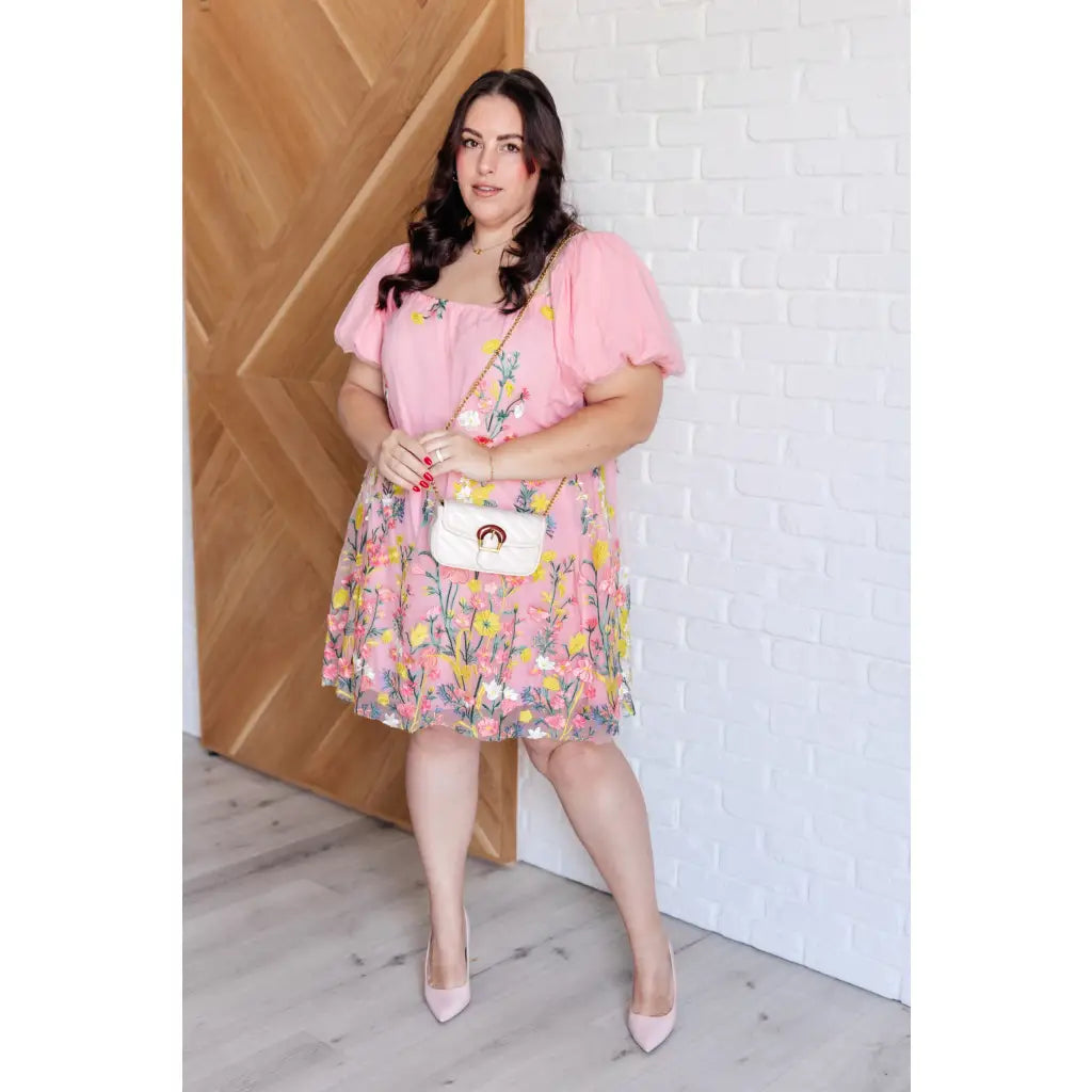 Our She’s Blooming Balloon Sleeve Mini Dress features a beautiful pink woven lining and an embroidered floral mesh