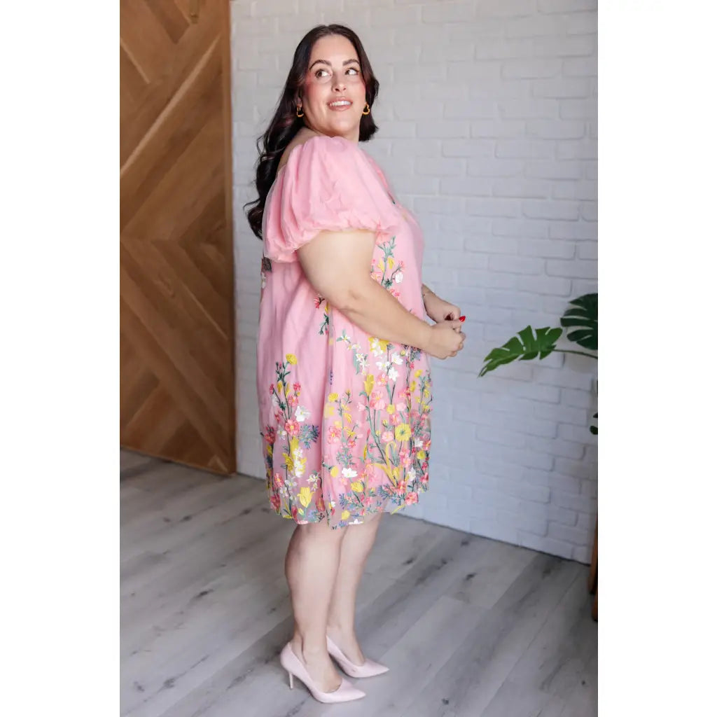Our She’s Blooming Balloon Sleeve Mini Dress features a beautiful pink woven lining and an embroidered floral mesh