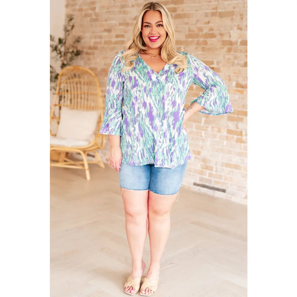 Shop the Spring into Action Bell Sleeve Top in mint and lavender abstract print. Wrinkle resistant flowy