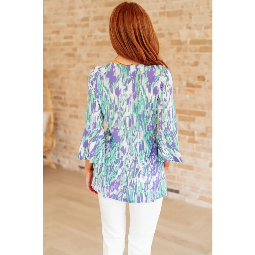 Shop the Spring into Action Bell Sleeve Top in mint and lavender abstract print. Wrinkle resistant flowy
