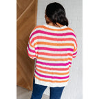 Loose knit striped sweater in coral and magenta. Plus size friendly fit with V-neck side slits. Cozy layering piece