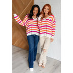 Loose knit striped sweater in coral and magenta. Plus size friendly fit with V-neck side slits. Cozy layering piece