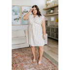 Look stunning in the Twisted and Tailored Vertical Striped Dress! Featuring a knotted front deep v-neck faux wrap. Plus