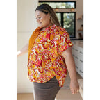 Make a statement in the Two Sides to Story Blouse! Half solid orange half paisley and floral mix print short sleeve top