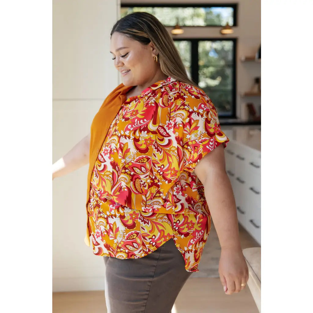 Make a statement in the Two Sides to Story Blouse! Half solid orange half paisley and floral mix print short sleeve top