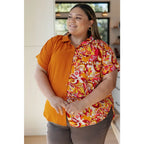 Make a statement in the Two Sides to Story Blouse! Half solid orange half paisley and floral mix print short sleeve top