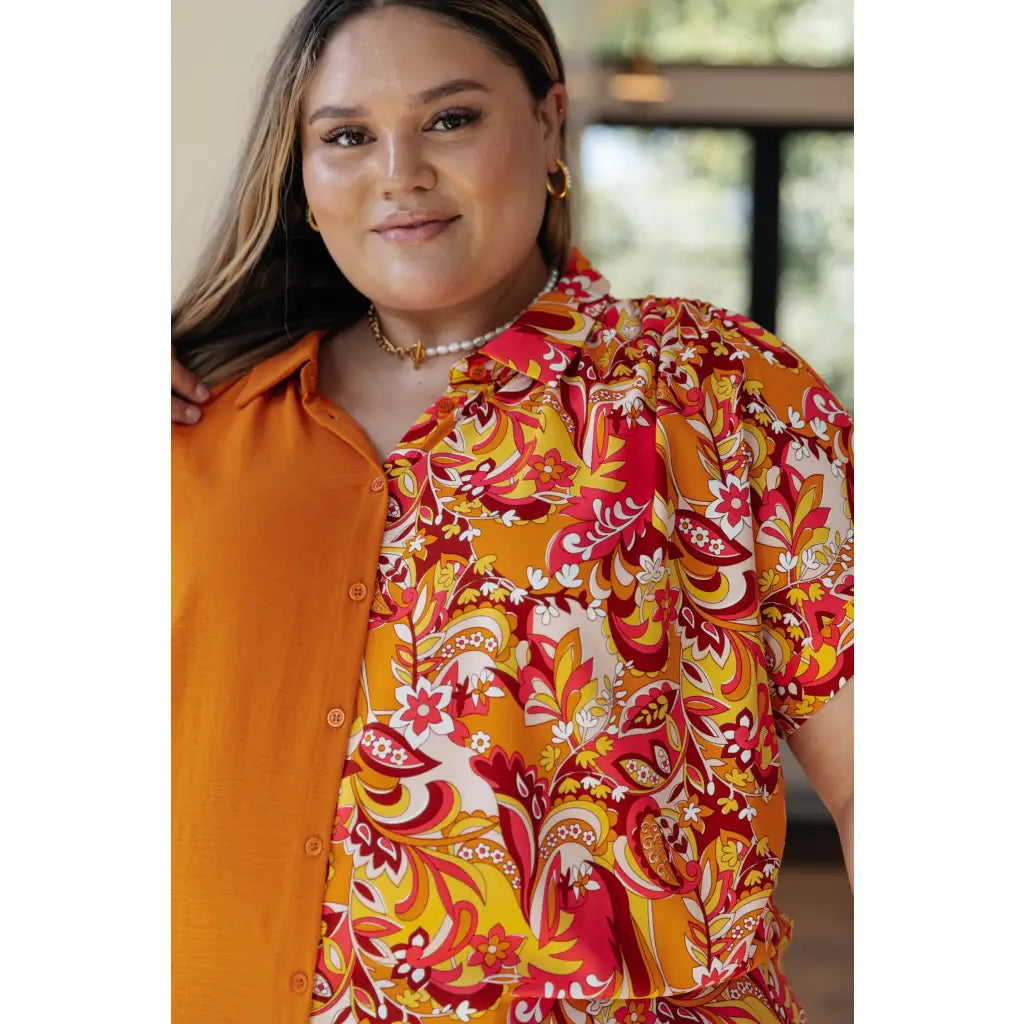 Make a statement in the Two Sides to Story Blouse! Half solid orange half paisley and floral mix print short sleeve top