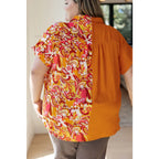 Make a statement in the Two Sides to Story Blouse! Half solid orange half paisley and floral mix print short sleeve top