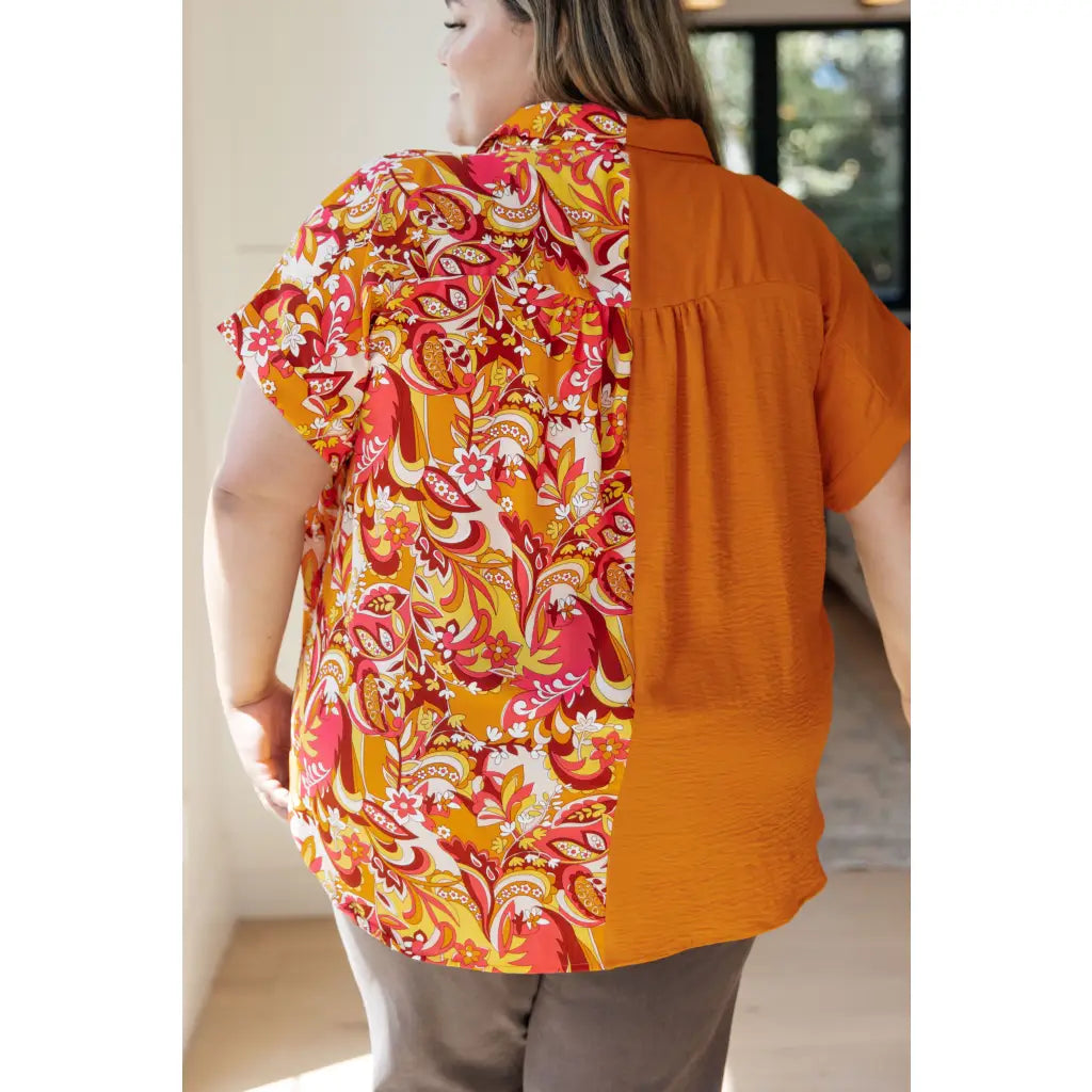 Make a statement in the Two Sides to Story Blouse! Half solid orange half paisley and floral mix print short sleeve top