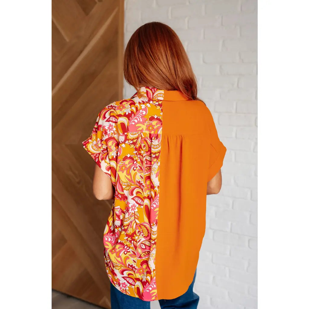 Make a statement in the Two Sides to Story Blouse! Half solid orange half paisley and floral mix print short sleeve top