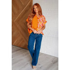 Make a statement in the Two Sides to Story Blouse! Half solid orange half paisley and floral mix print short sleeve top