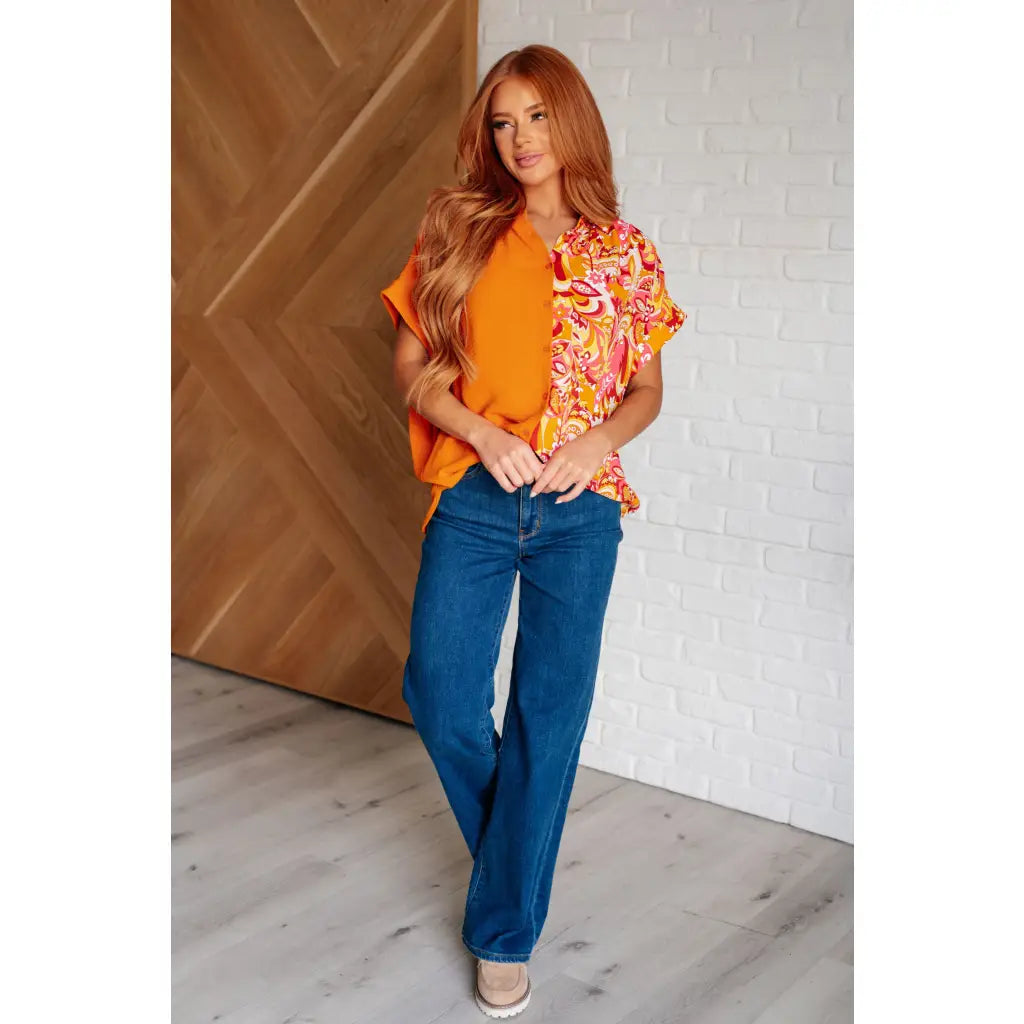 Make a statement in the Two Sides to Story Blouse! Half solid orange half paisley and floral mix print short sleeve top