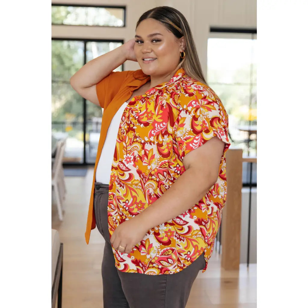Make a statement in the Two Sides to Story Blouse! Half solid orange half paisley and floral mix print short sleeve top